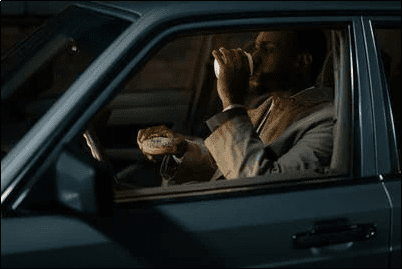 A PCO driver having a snack in his car