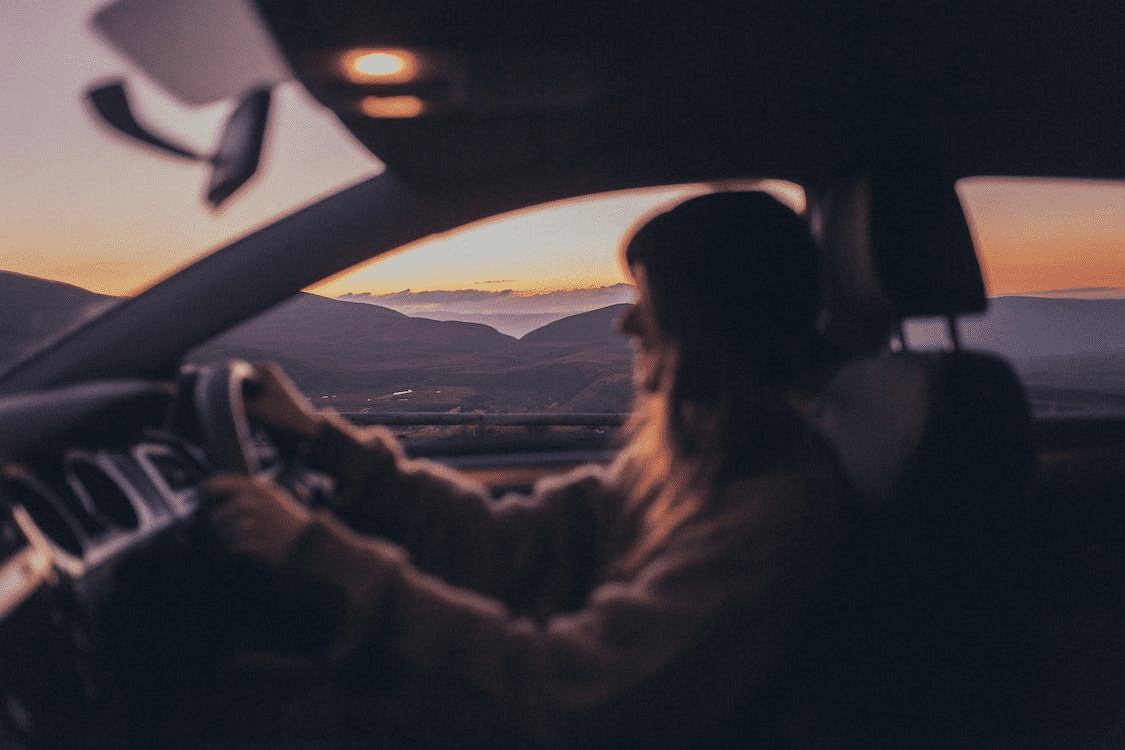 A woman driving at sunset