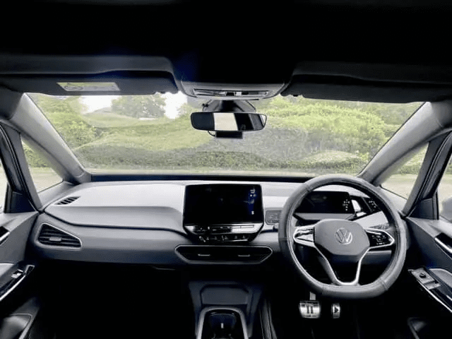 the interior of an ID3 electric PCO car for rent in London with a view of a garden visible from the windscreen