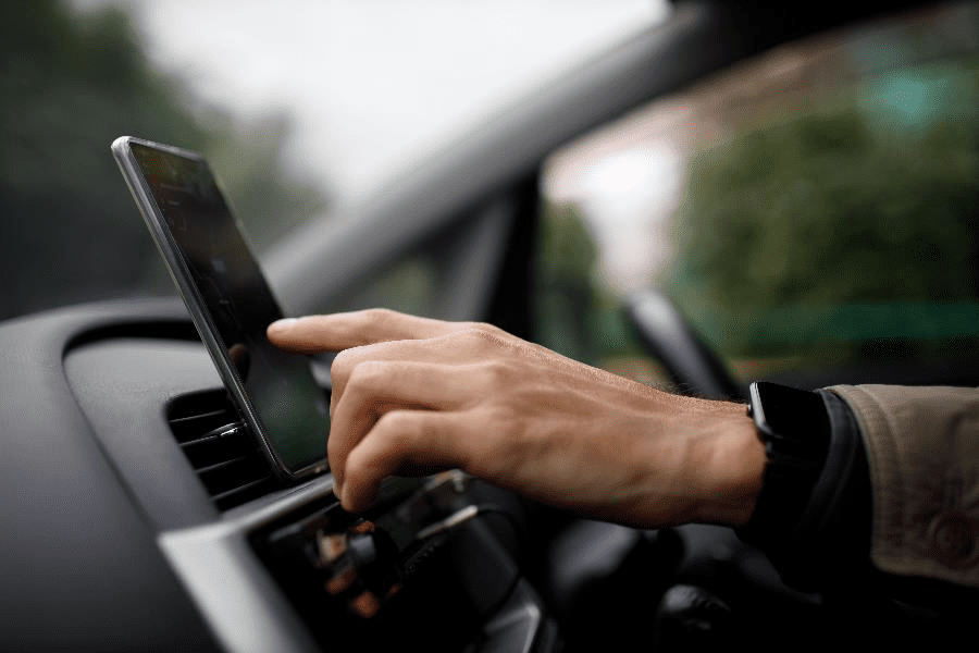 A PCO car driver using a navigation app on his phone